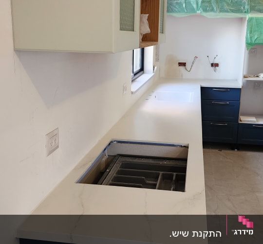 משטח שיש לבן עם כיור מובנה במטבח